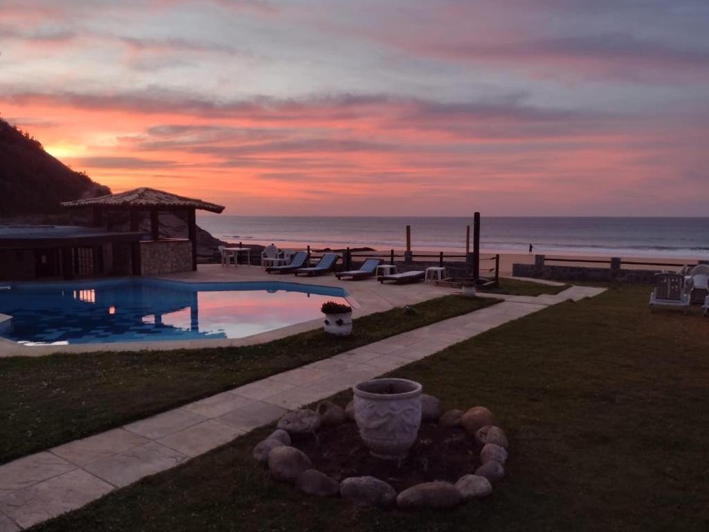 Piscina ao pôr do sol com o morro ao lado