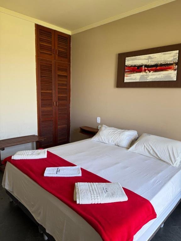 Suíte com cama de casal e armário de madeira